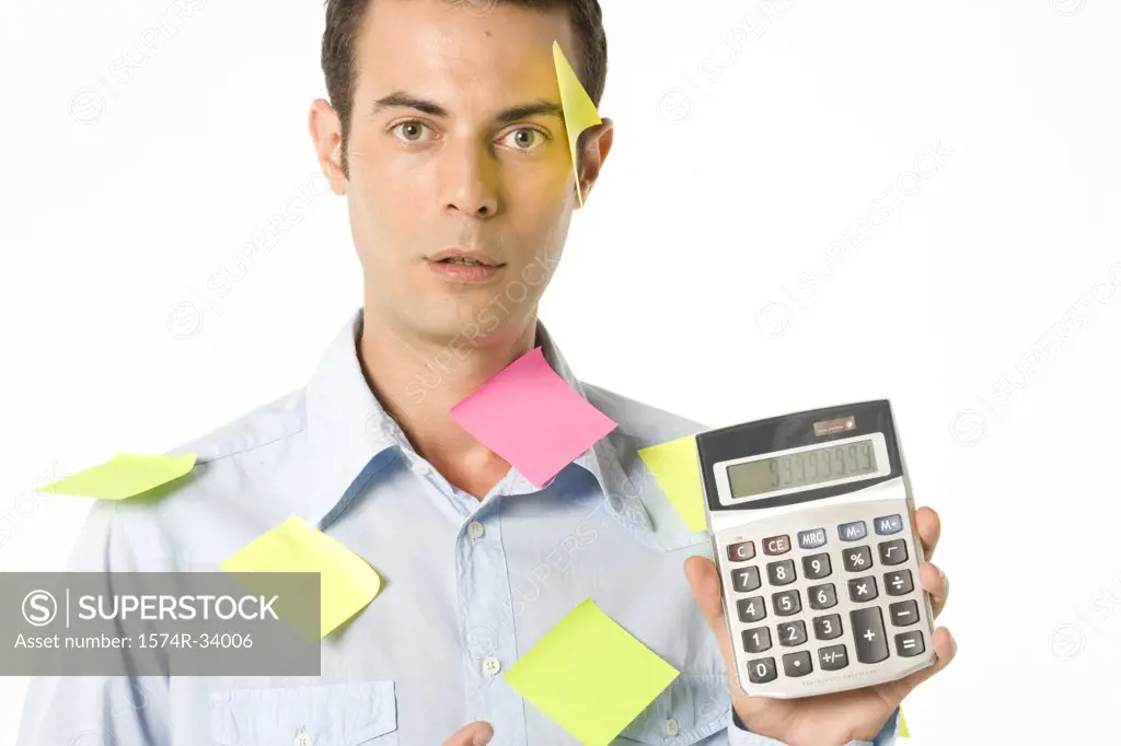 Portrait of a businessman holding a calculator with adhesive notes on his shirt