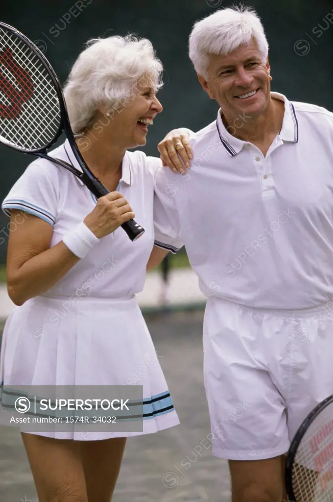 Senior couple walking on a tennis court