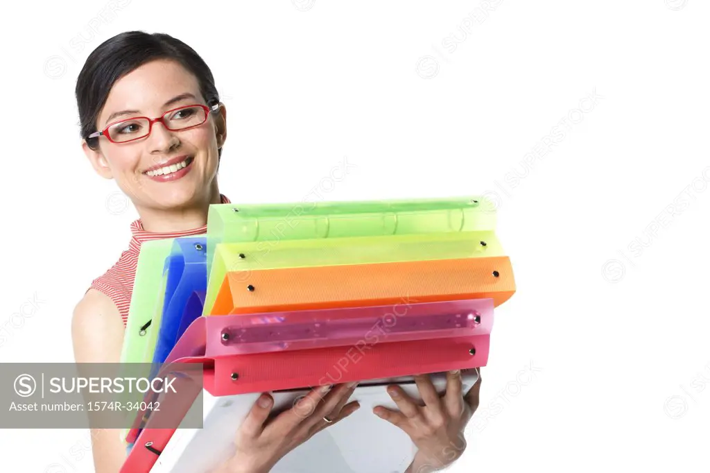 Businesswoman holding a stack of ring binders and smiling