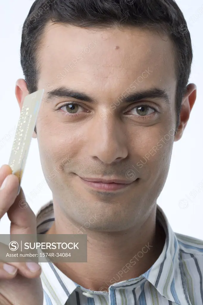 Portrait of a young man holding a credit card