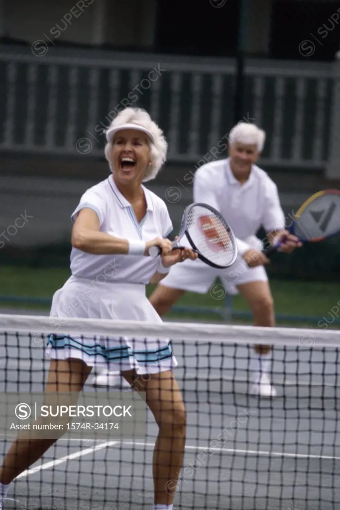 Senior couple playing a mixed doubles tennis match