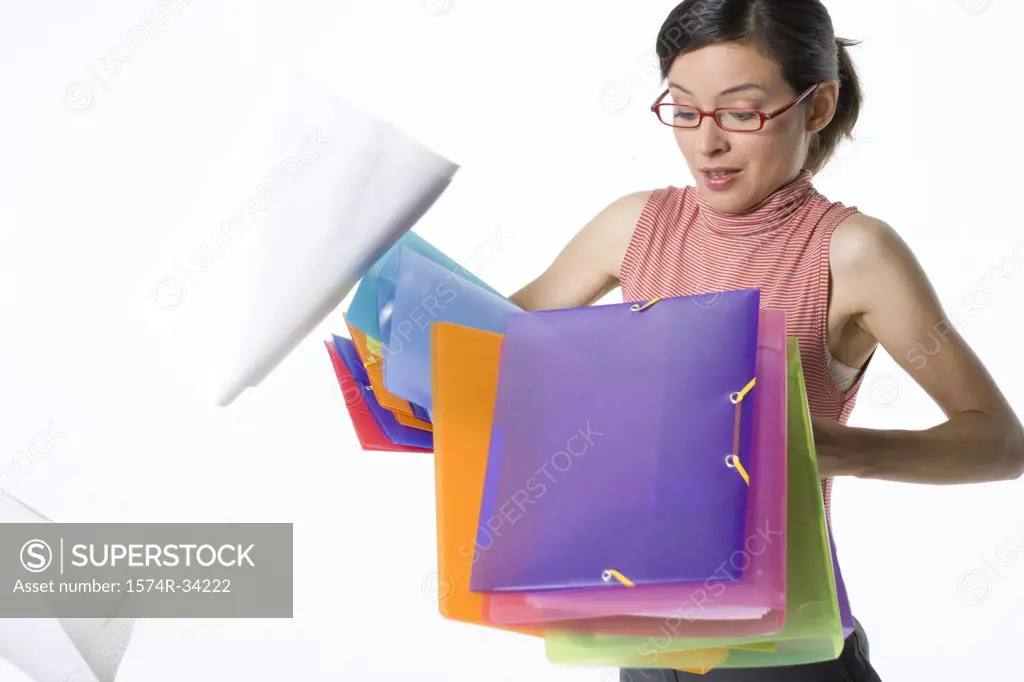 Stack of ring binders falling from a businesswoman's hands