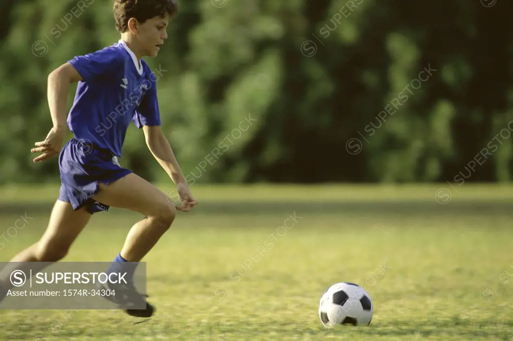 Boy playing soccer in a soccer field