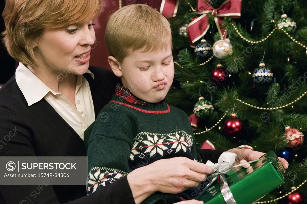 Mature woman opening a present with her grandson
