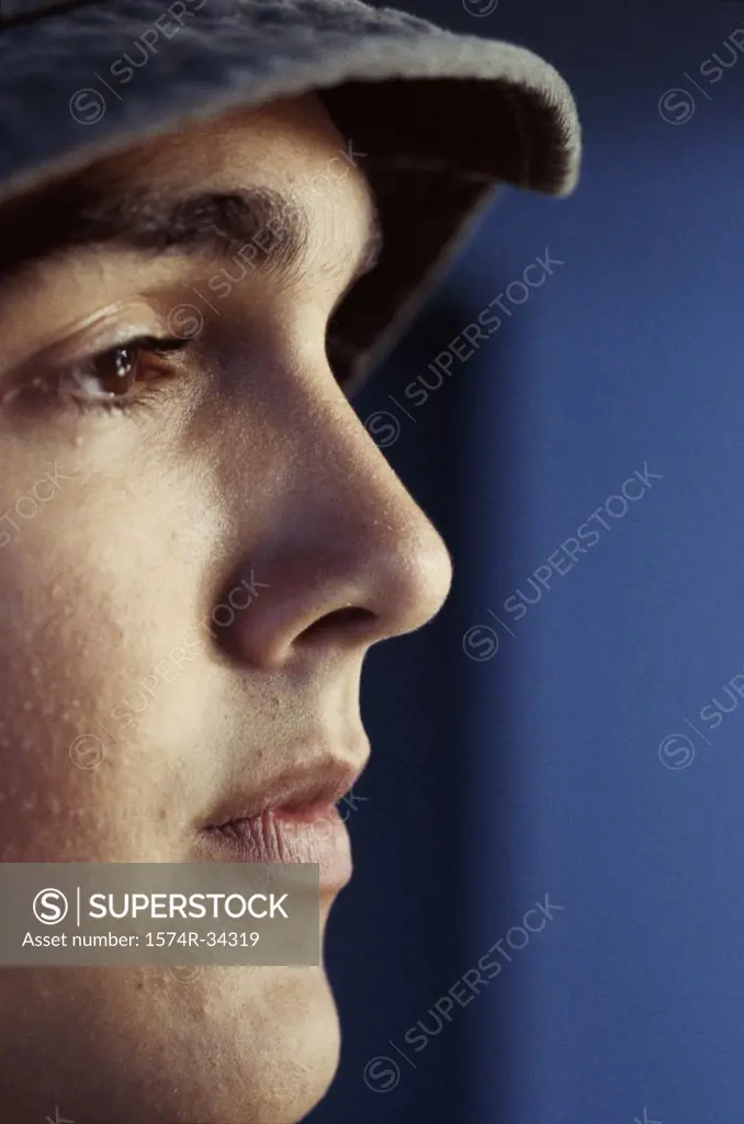 Side profile of a teenage boy wearing a baseball cap