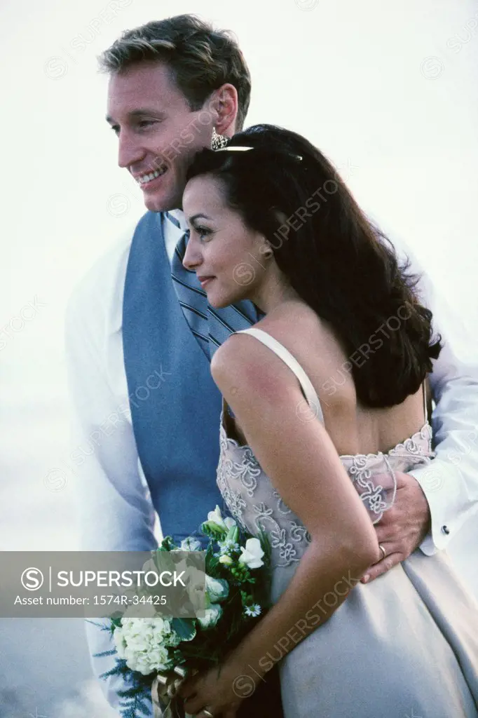 Groom embracing her bride