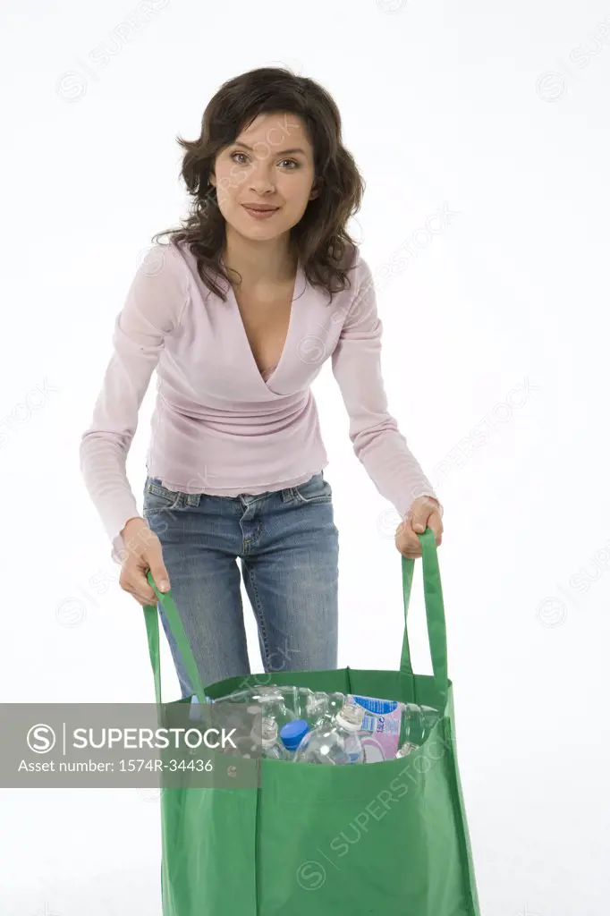 Young woman holding a bag of plastic bottles for recycling