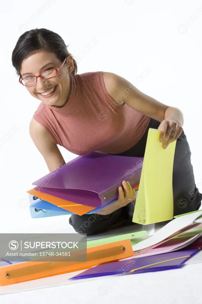 Businesswoman picking up ring binders and smiling