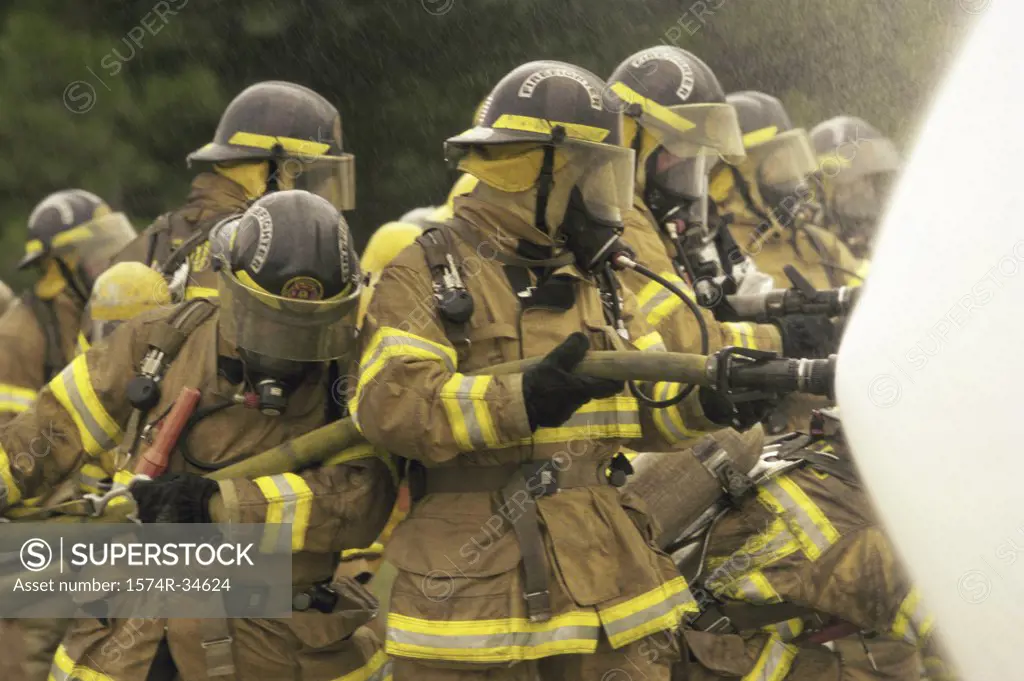 Group of firefighters holding water hoses