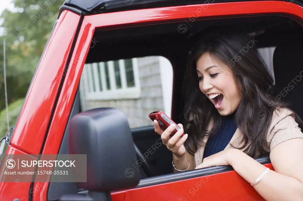 Woman holding mobile phone and looking surprised