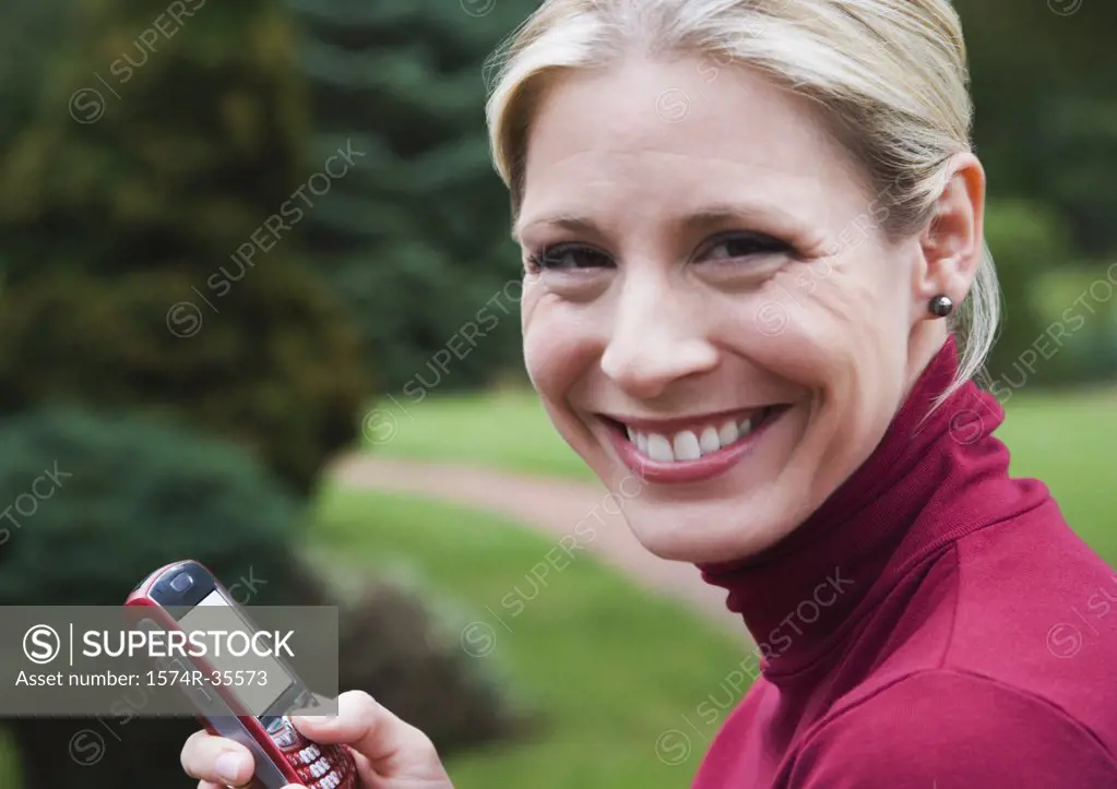 Woman holding a mobile phone and smiling