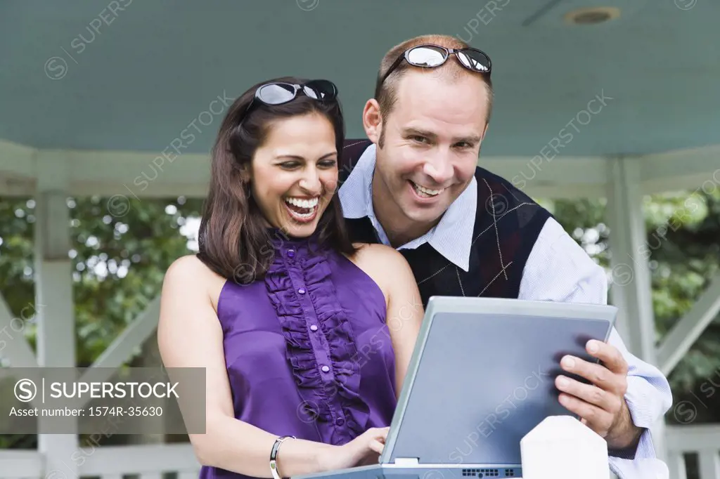 Businesswoman and businessman working on laptop