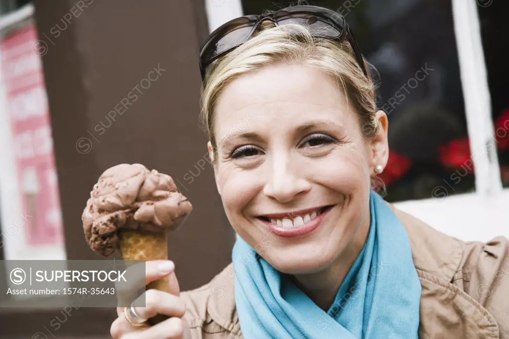Woman holding an ice-cream cone and smiling