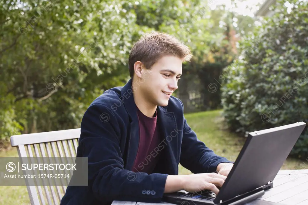 Man working on laptop in lawn