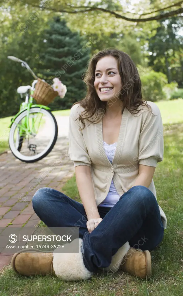 Happy woman sitting in a lawn and smiling