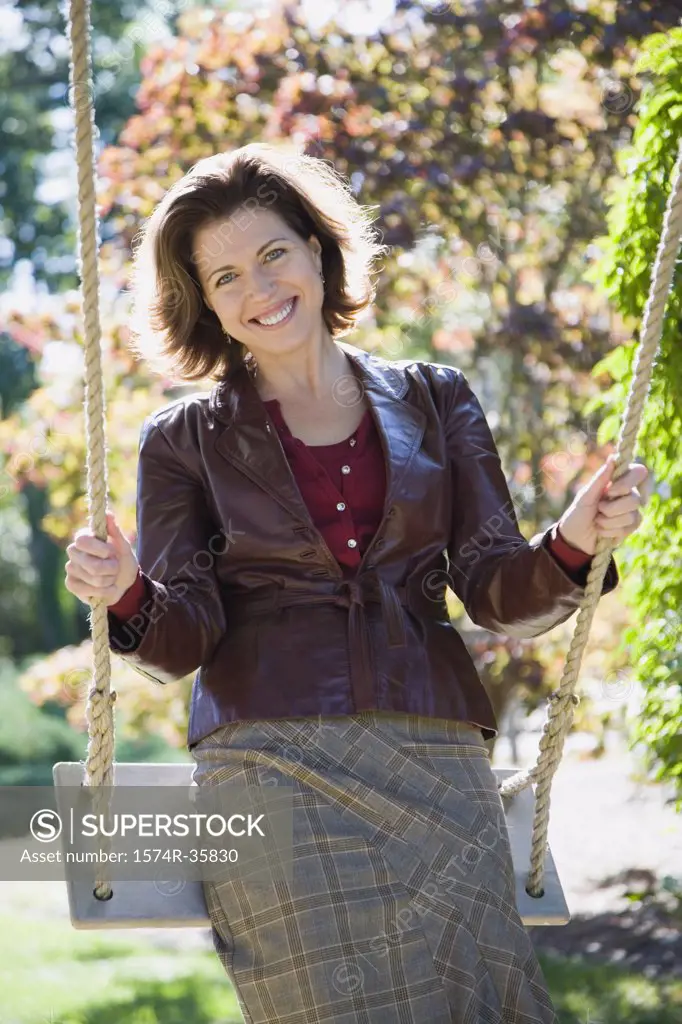 Woman swinging on rope swing and smiling