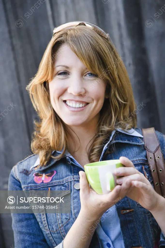 Woman holding cup of coffee and smiling