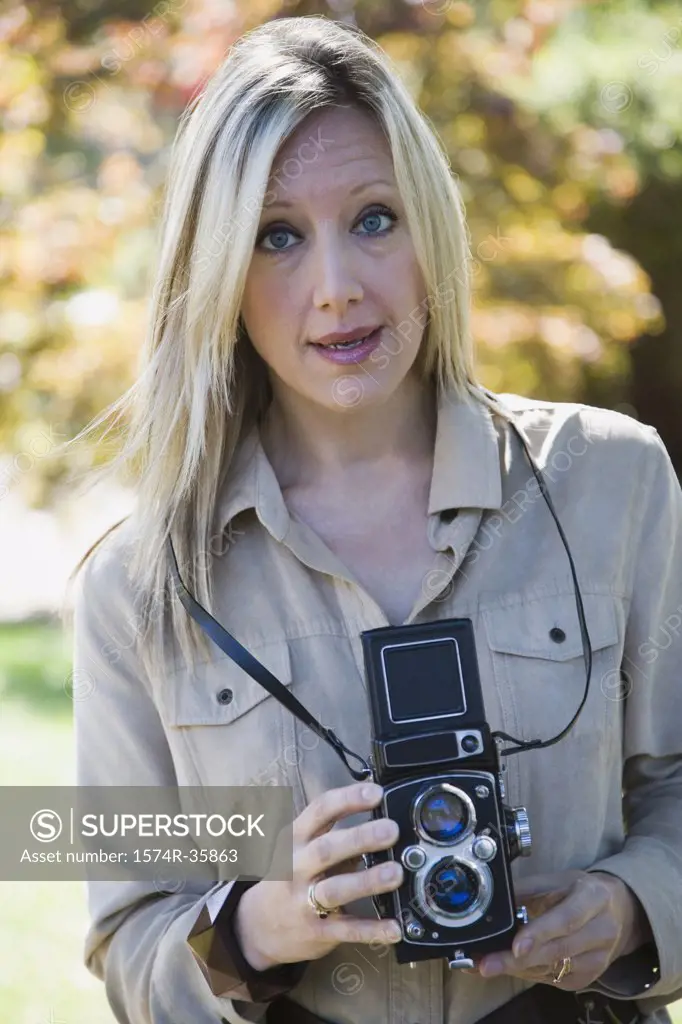 Portrait of woman holding twin lens camera