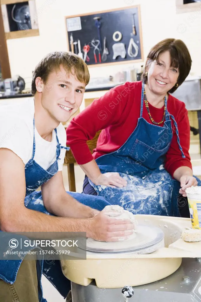 Student with his professor in a pottery class