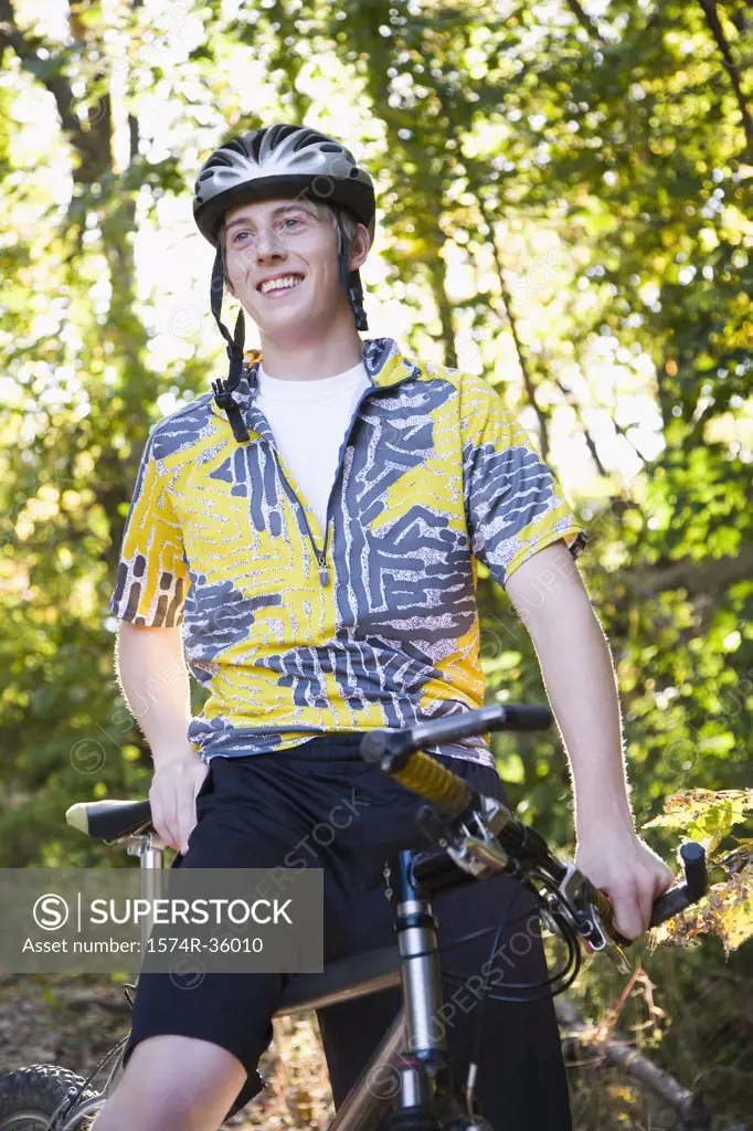 Teenage boy riding a mountain bike in a forest