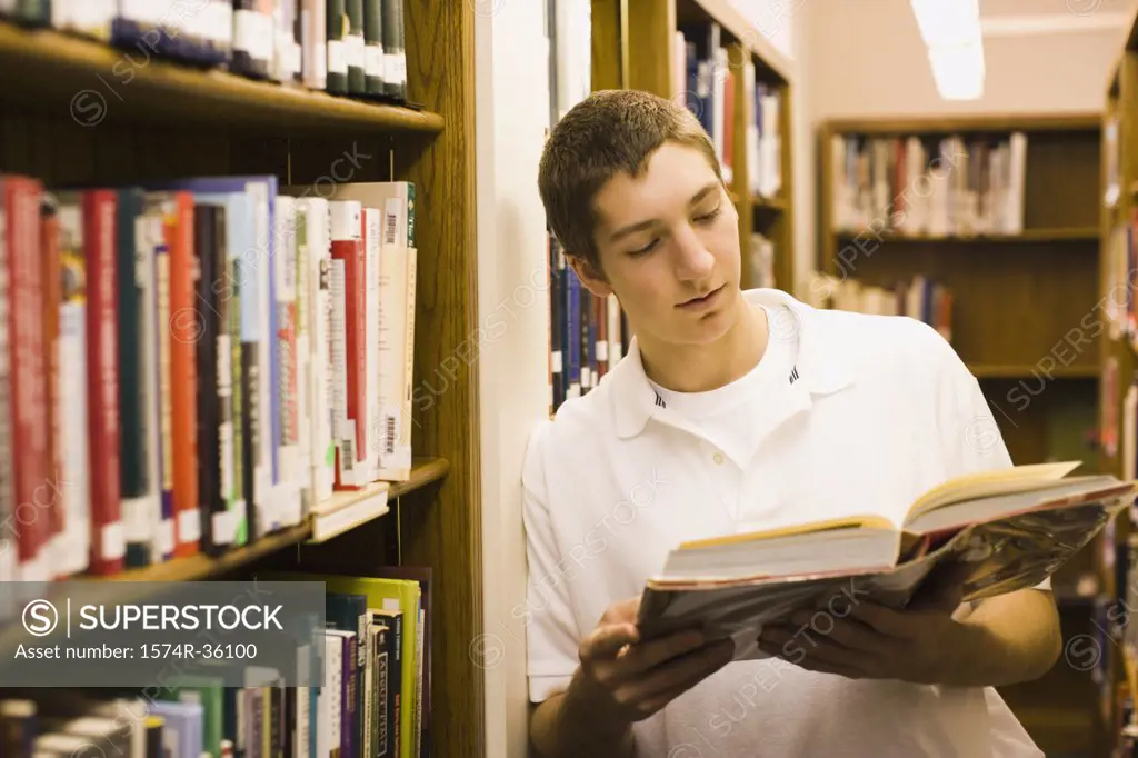 Student reading a book in a library