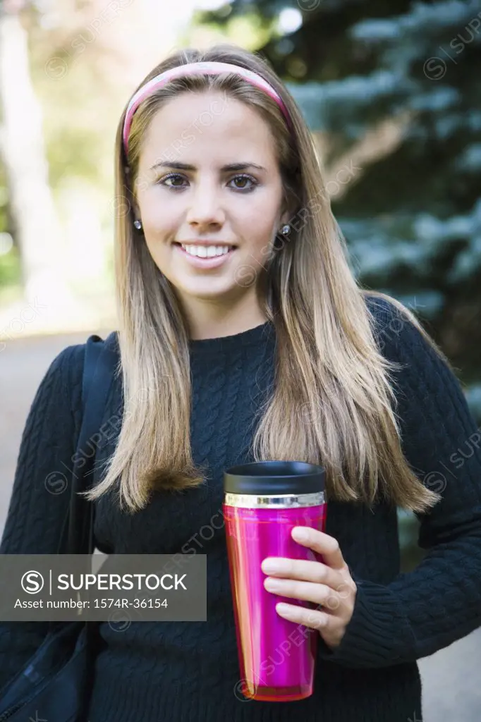 Woman holding an insulated drink container