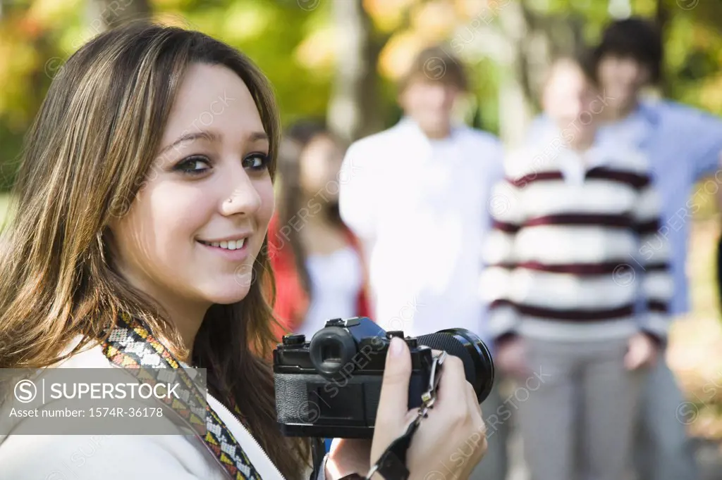 Student holding a digital camera and smiling