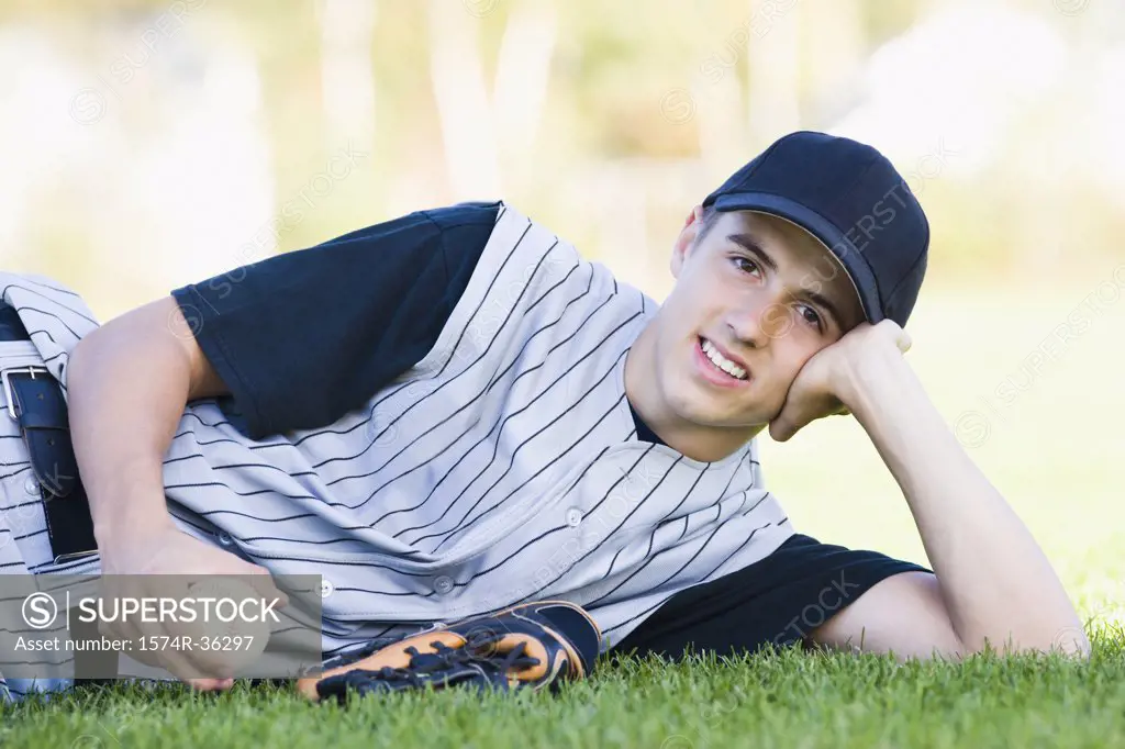 Teenage boy reclining and holding a baseball