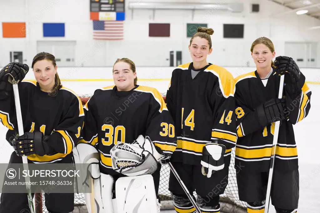 Four female ice hockey players standing in an ice rink