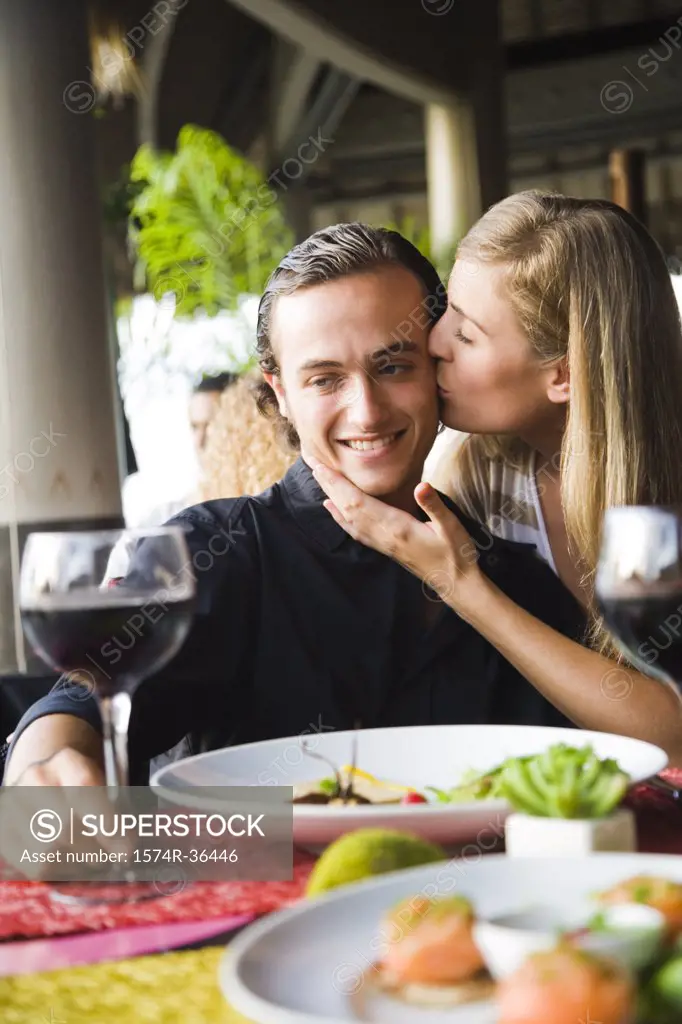 Woman kissing a man in a restaurant, Papeete, Tahiti, French Polynesia