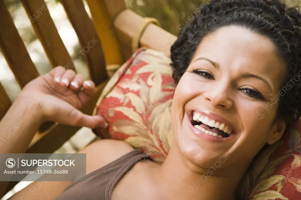 Portrait of a woman lying on a bench and laughing
