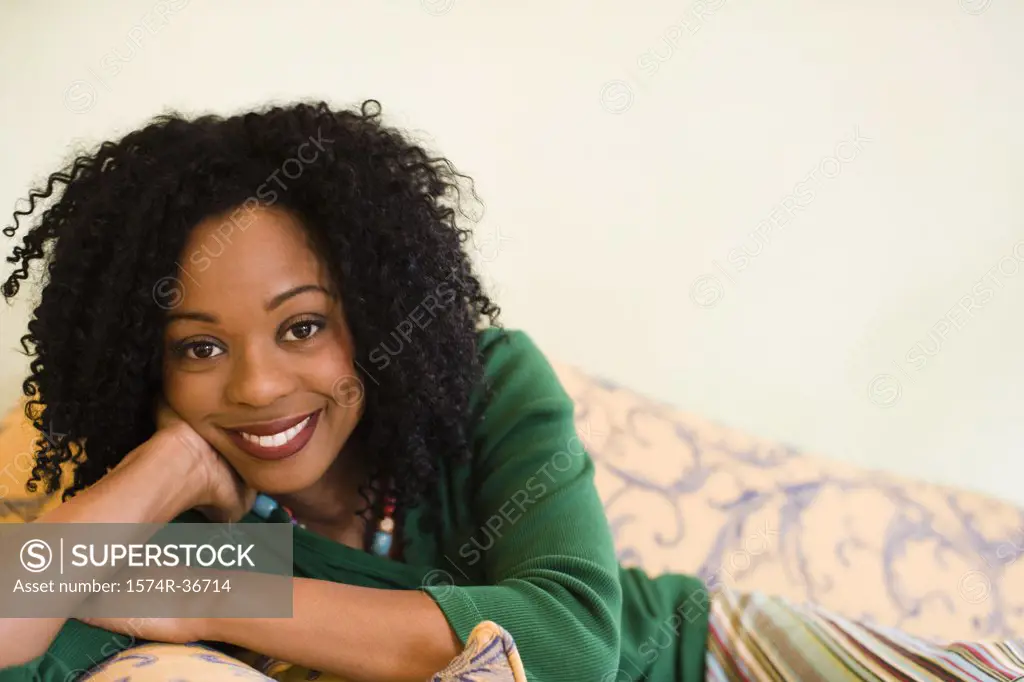 Portrait of a woman leaning on a couch and smiling