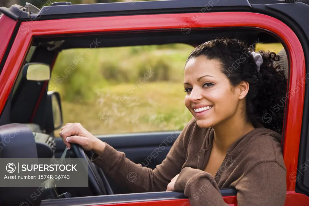 Portrait of a woman sitting in a car and smiling