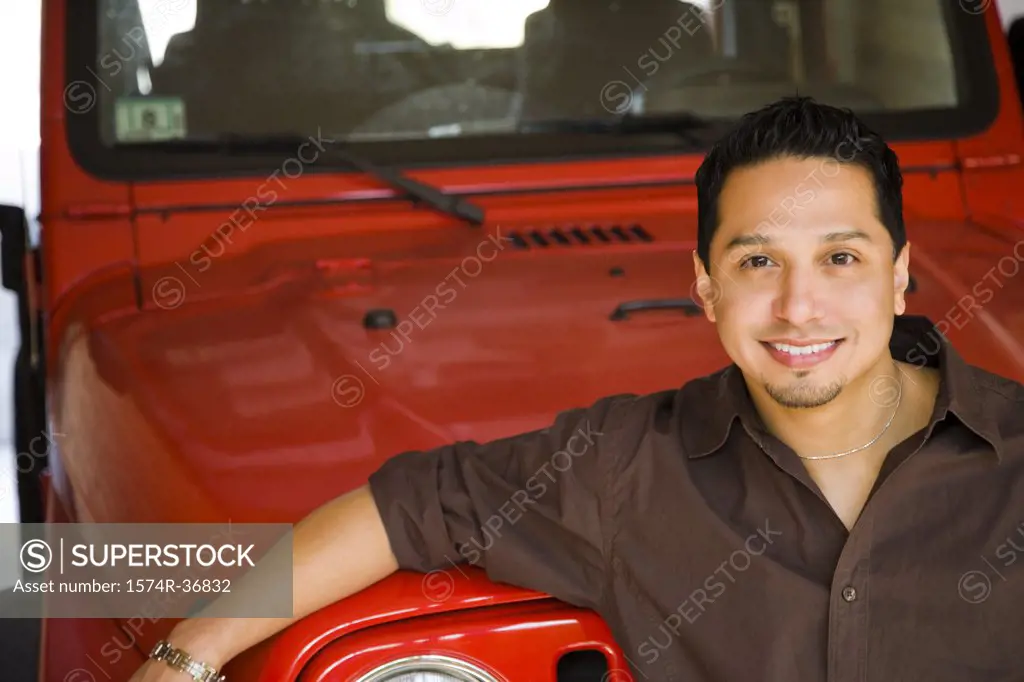 Portrait of a man leaning against a car and smiling