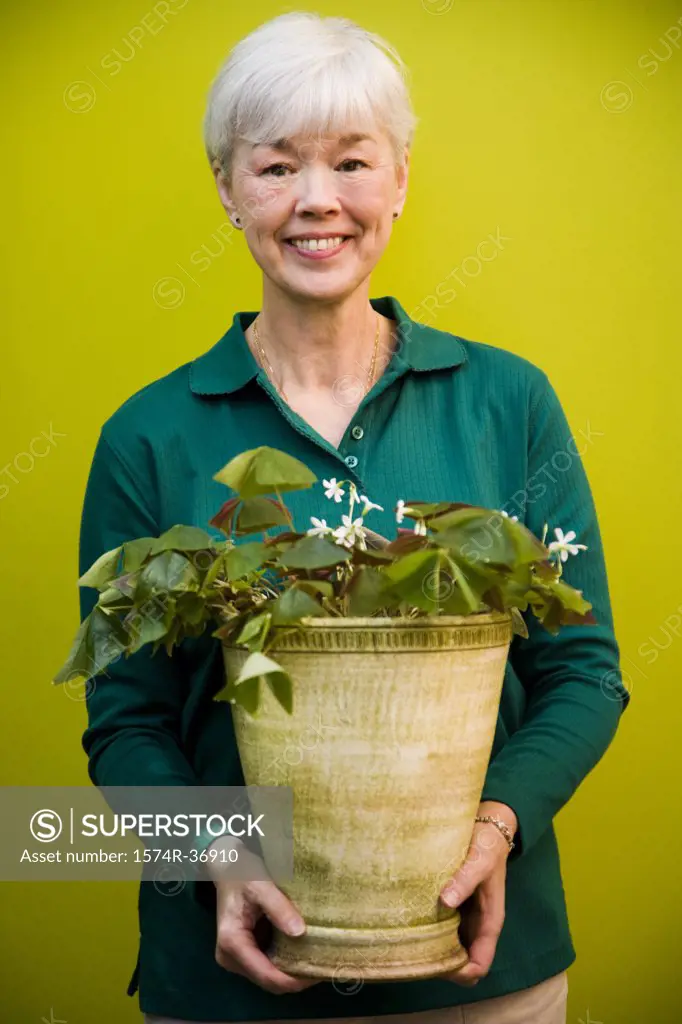 Portrait of a woman holding a potted plant and smiling