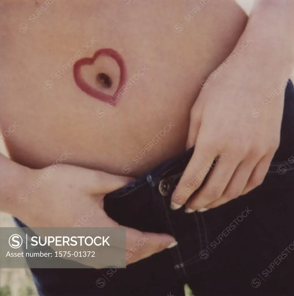 Closeup of womans stomach with heart drawn around belly button