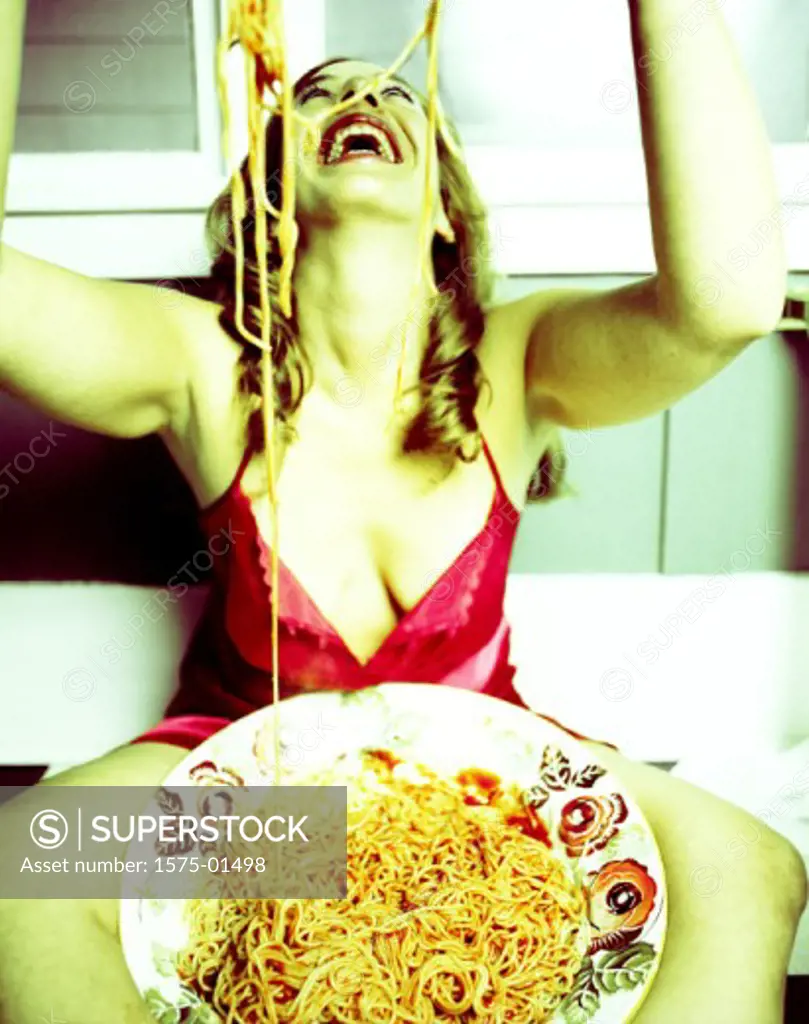 Young woman sitting with spaghetti on her head
