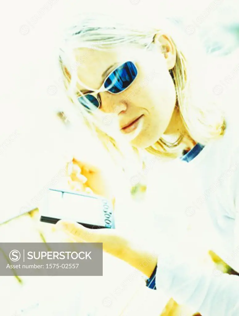 Over-exposed portrait of a blonde woman holding a palm pilot