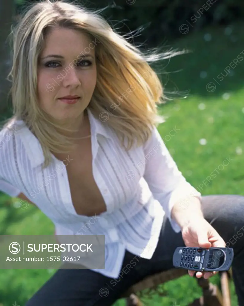 Woman sitting outdoors with cellular phone