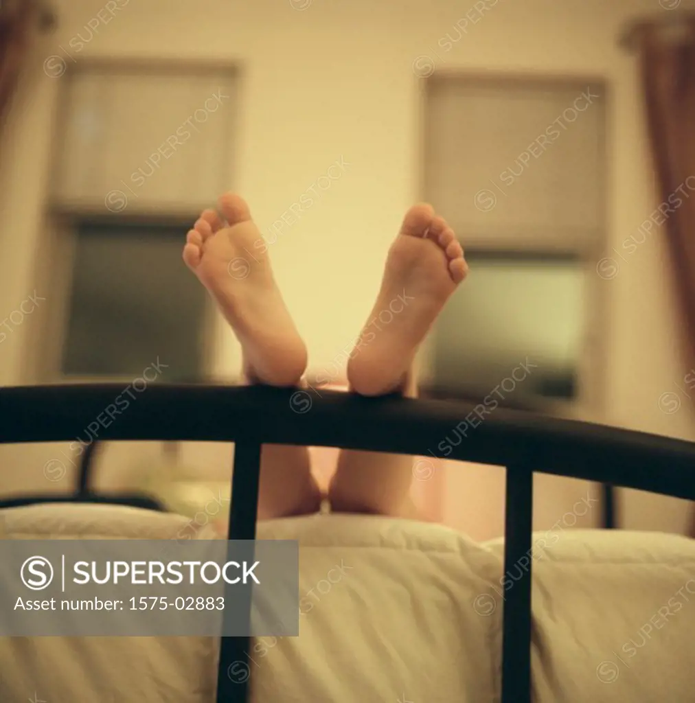 Feet resting on bed frame