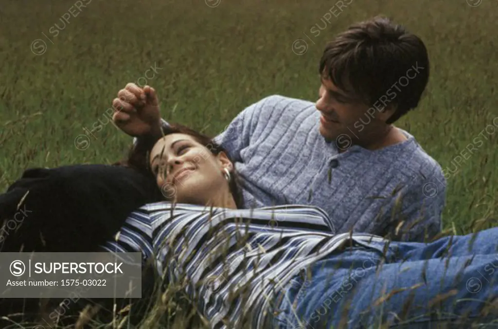 Couple lying in field of grass