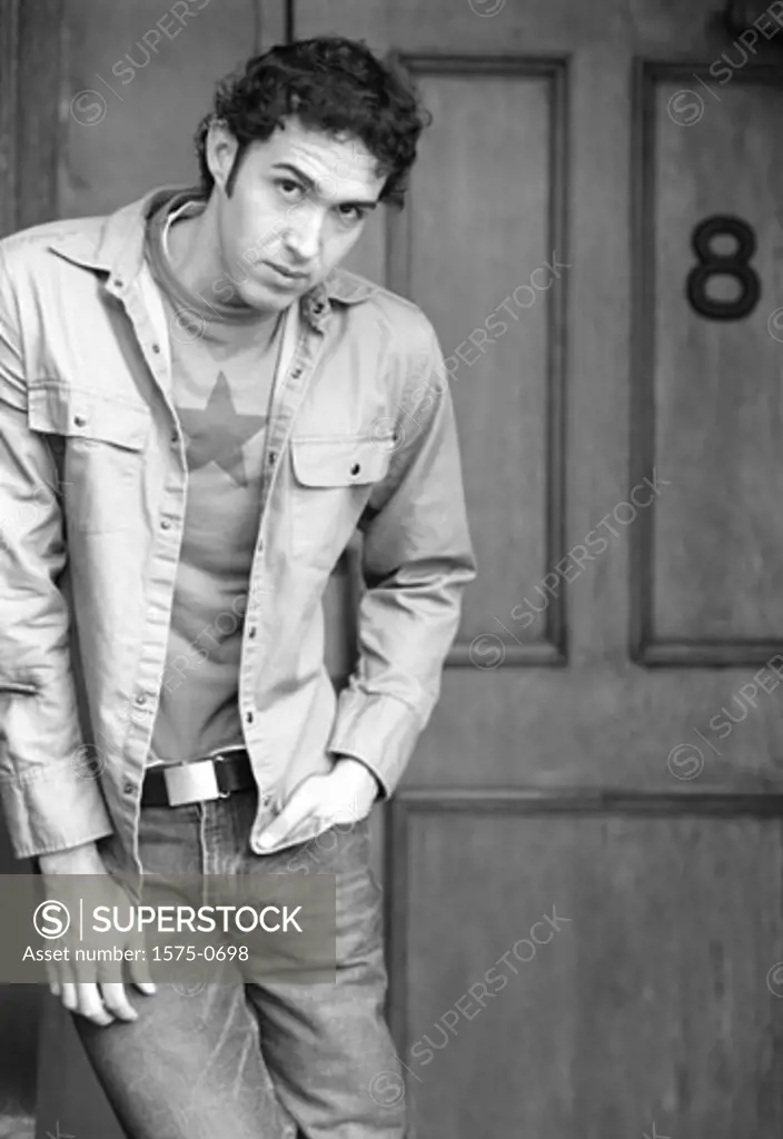 Portrait of young man standing in doorway