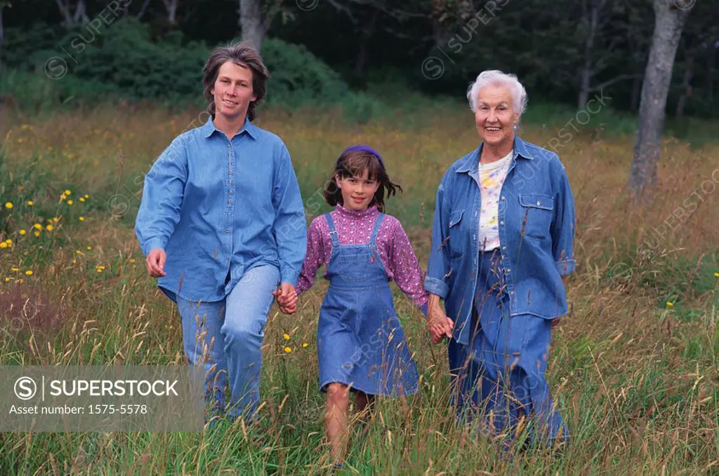 Three generations of women walking in a field