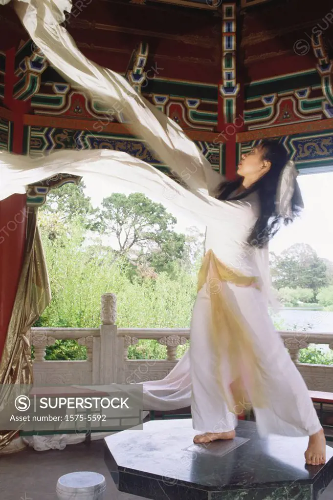 Asian woman standing on table fabric flowing