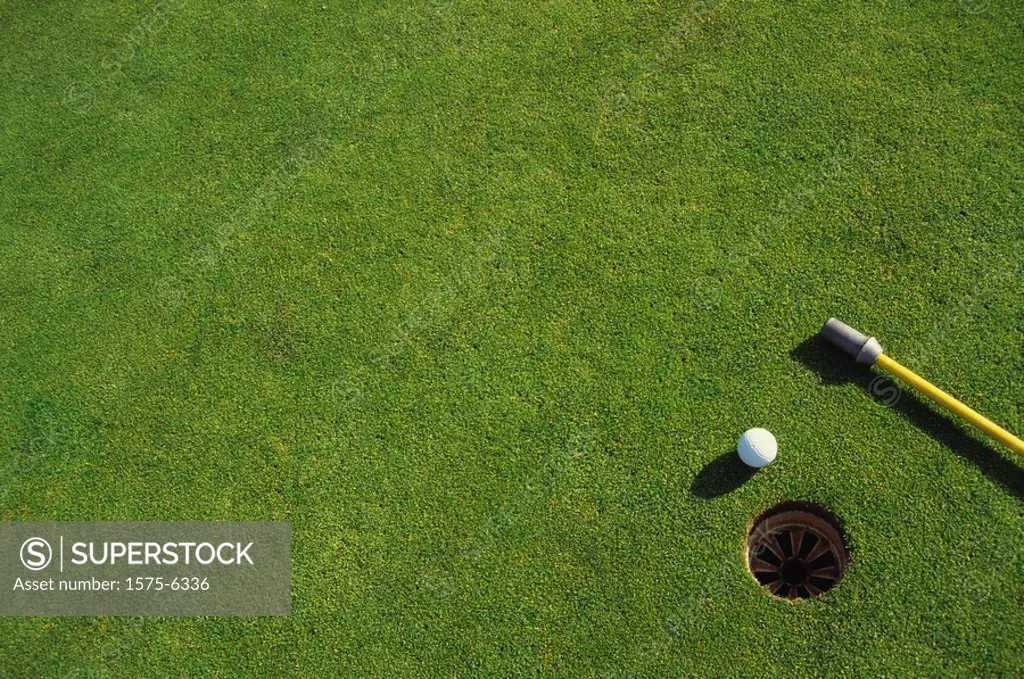 Golf ball near hole and flag bottom