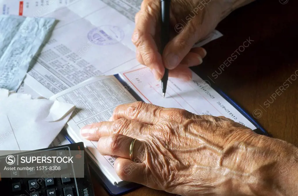 Senior woman writing bills
