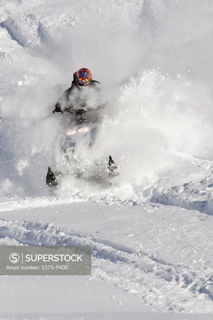Man on snowmobile in deep powder, Whistler, British Columbia, Canada