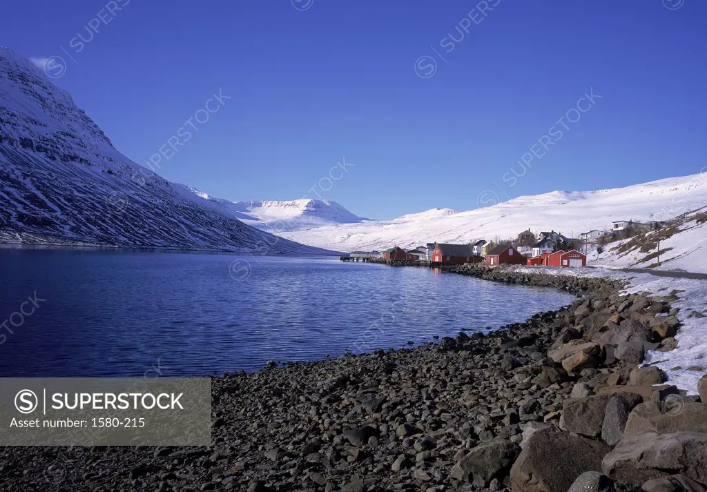 Panoramic view of a lake surrounded by snow covered mountains, Eskifjordur, Iceland