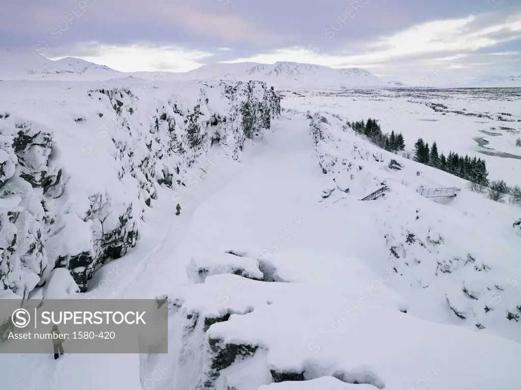 High angle view of two people walking in a snow covered landscape, Thingvellir National Park, Iceland
