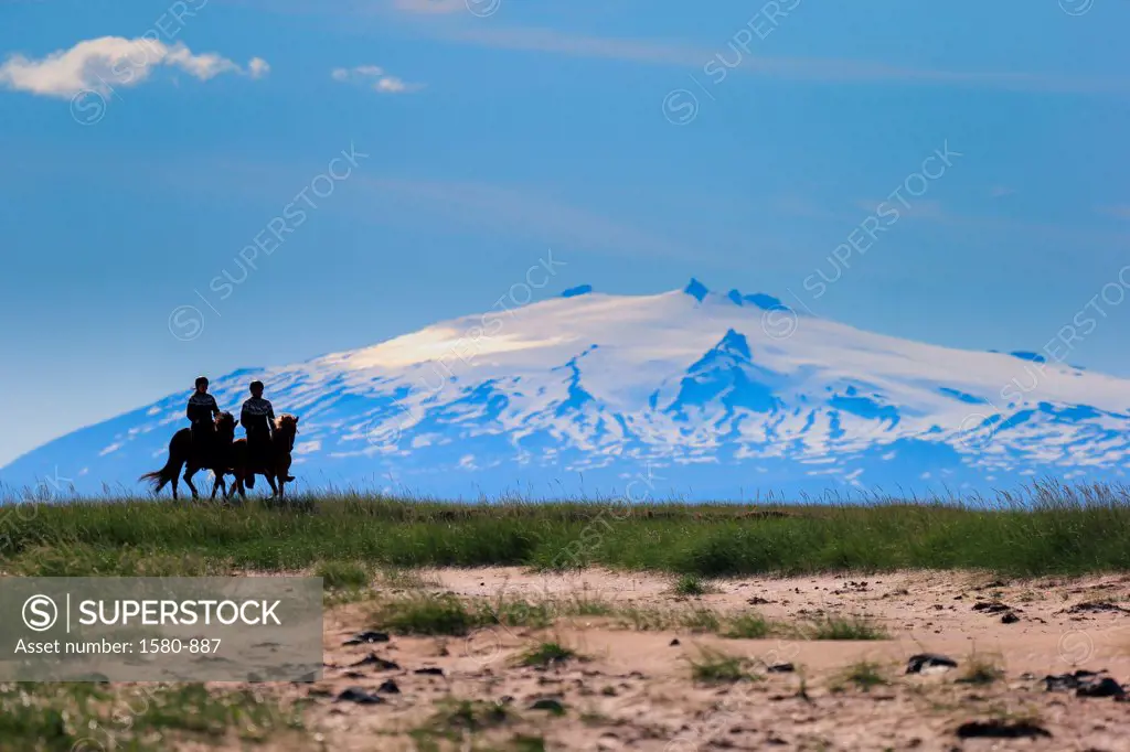 Iceland, Snaefellsnes Peninsula, Longufjordur, Horseback riding, Snaefellsjokull Glacier in background
